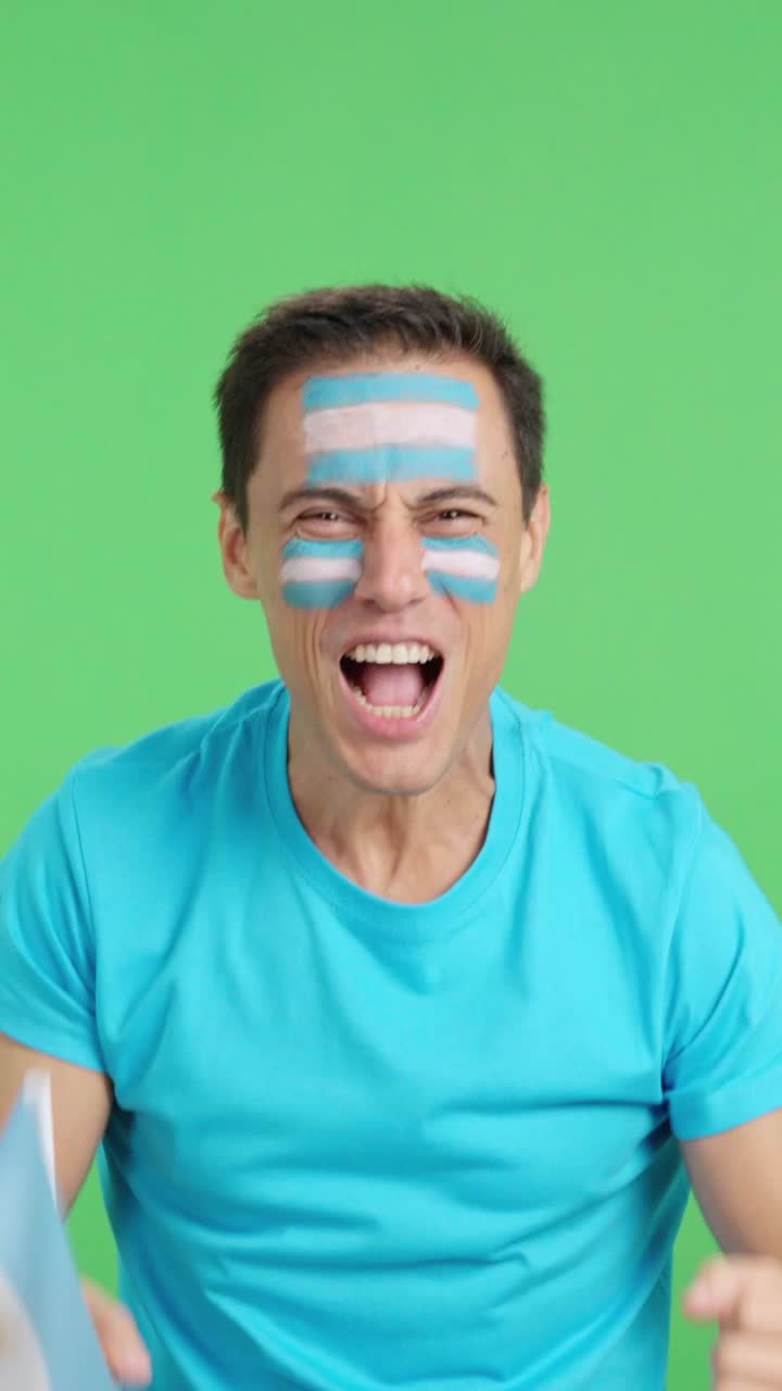 Man cheering for Argentina screaming and waving a national flag