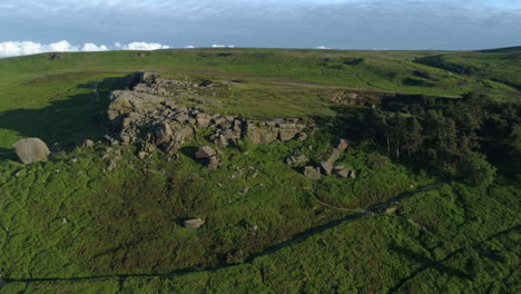 Establishing-Drone-Shot-Towards-Cow-and-Calf-Rock-Formation-on-Ilkley-Moor-at-Golden-Hour-West-Yorkshire-UK