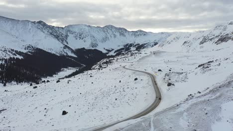 雪地冬天,在鄉村公路上的汽車的空中景色,岩石山脈的風景,傾斜的無人機拍攝