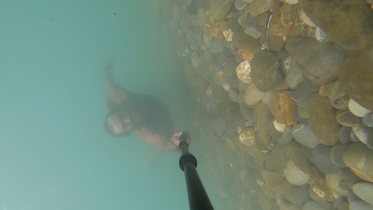 필리핀 의 다채로운 강 에서 강류 를 떠다니는 매우 긴 머리카락 을 가진 건강 한 남자 의 수직 동영상