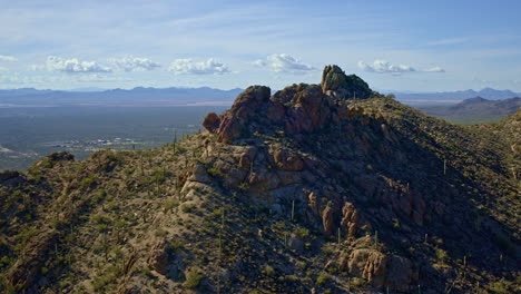 drone shot flying towards edge of the ridge of a desert mountain range in tucson arizona