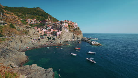 cinque terre con los pueblos monterosso, vernazza, corniglia, manarola y riomaggiore en la costa mediterránea de italia con barcos de pesca y turistas nadando