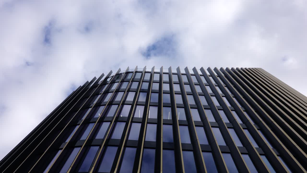 edificio futurista de fachada dorada con ventanas oscuras durante el día nublado, praga