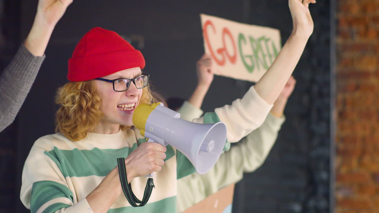 joven activista ambiental sosteniendo un megáfono y protestando con sus amigos contra la inacción del cambio climático