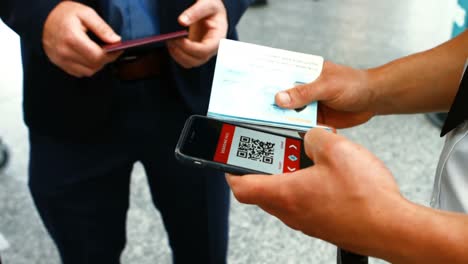 Airport-male-staff-using-mobile-phone-to-scan-the-passport