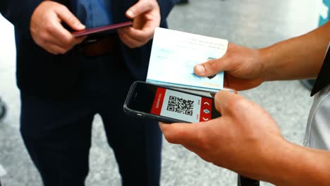 Personal-Masculino-Del-Aeropuerto-Usando-Un-Teléfono-Móvil-Para-Escanear-El-Pasaporte.