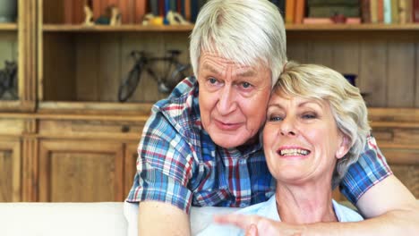 senior couple watching tv together in living room