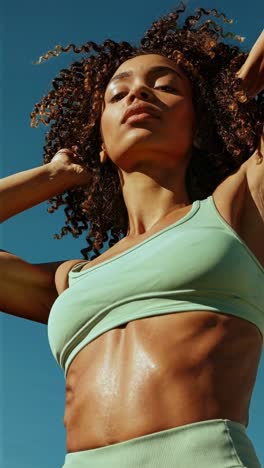 dynamic low-angle video shot of a woman in athletic wear, capturing movement and energy