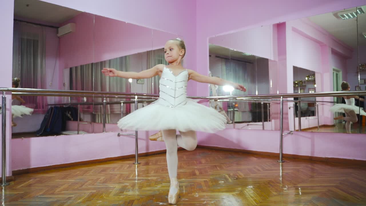 Ballerina dancing in studio in front of mirror. In the ballet hall. A little dancer.