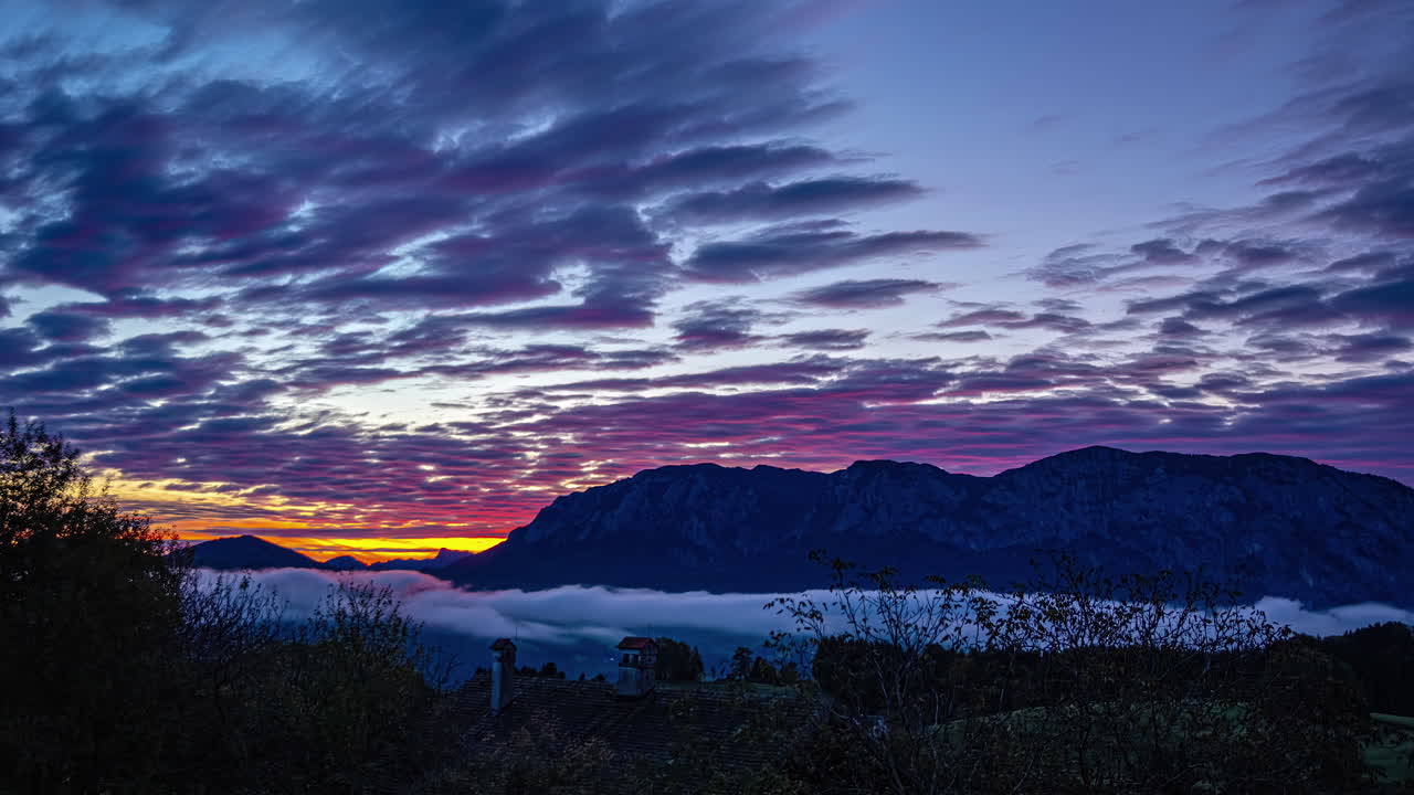 el lapso de tiempo de las hermosas nubes rodando sobre la colina, el atardecer colorido, naranja, púrpura, rojo, amarillo, azul
