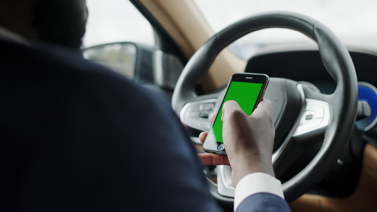 hombre usando teléfono con pantalla verde. hombre escribiendo teléfono inteligente en el coche