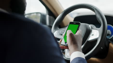 Back-view-man-using-phone-with-green-screen.-Man-typing-smartphone-at-car