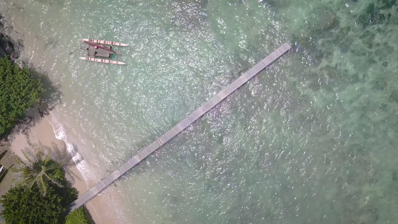 하와이의 빛 아래, 돌 모래의 열대 해변이 매혹적인 푸른 바다를 따라 어 있습니다.