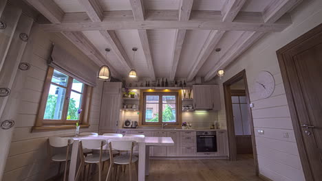 Shot-of-white-luxury-kitchen-with-beautiful-interiors-along-with-a-dinning-table-beside-a-window-in-timelapse-at-daytime