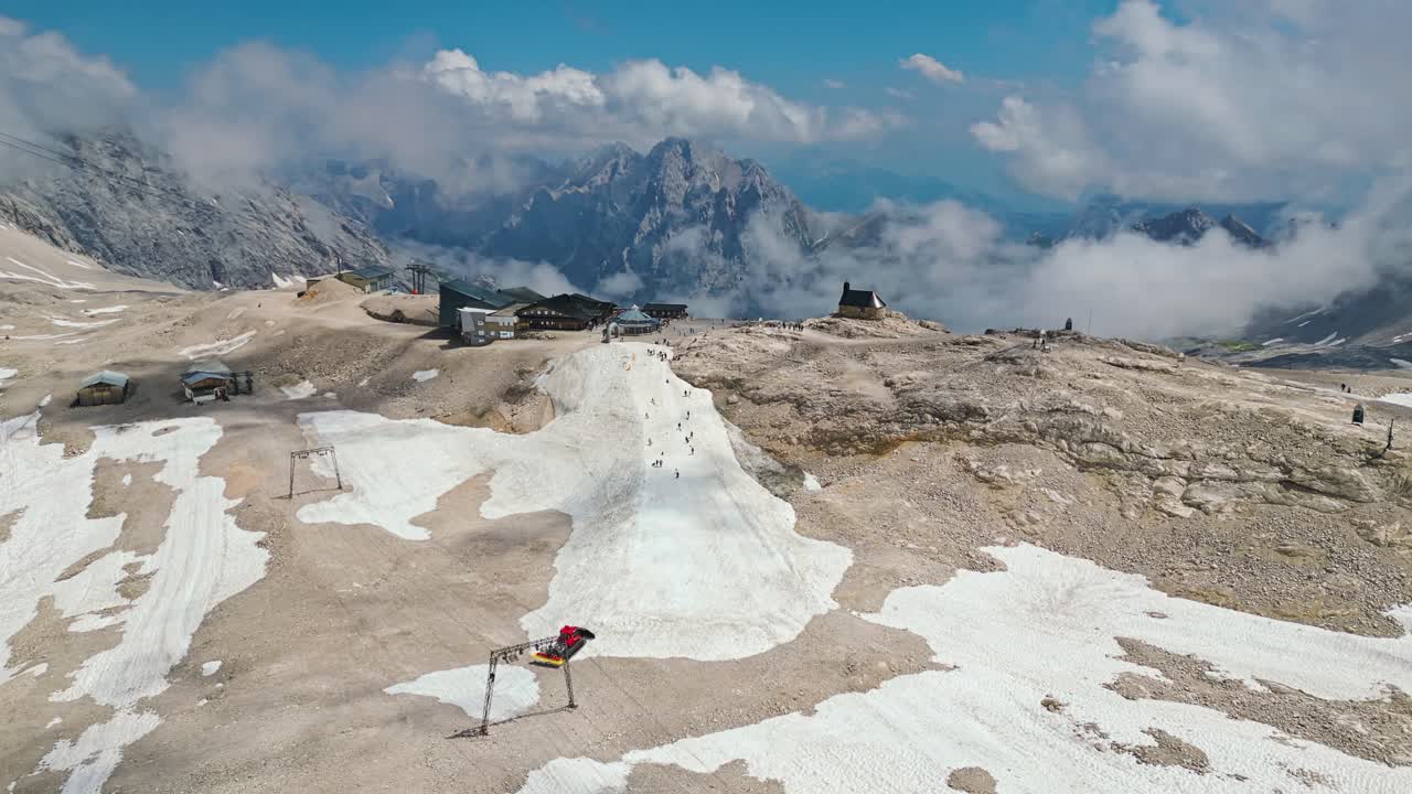 People playing in the snow in Zugspitze peak at sunny day