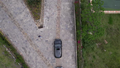 aerial-view-shows-a-long-line-of-cars-waiting-in-a-rural-environment,-surrounded-by-fields-and-trees