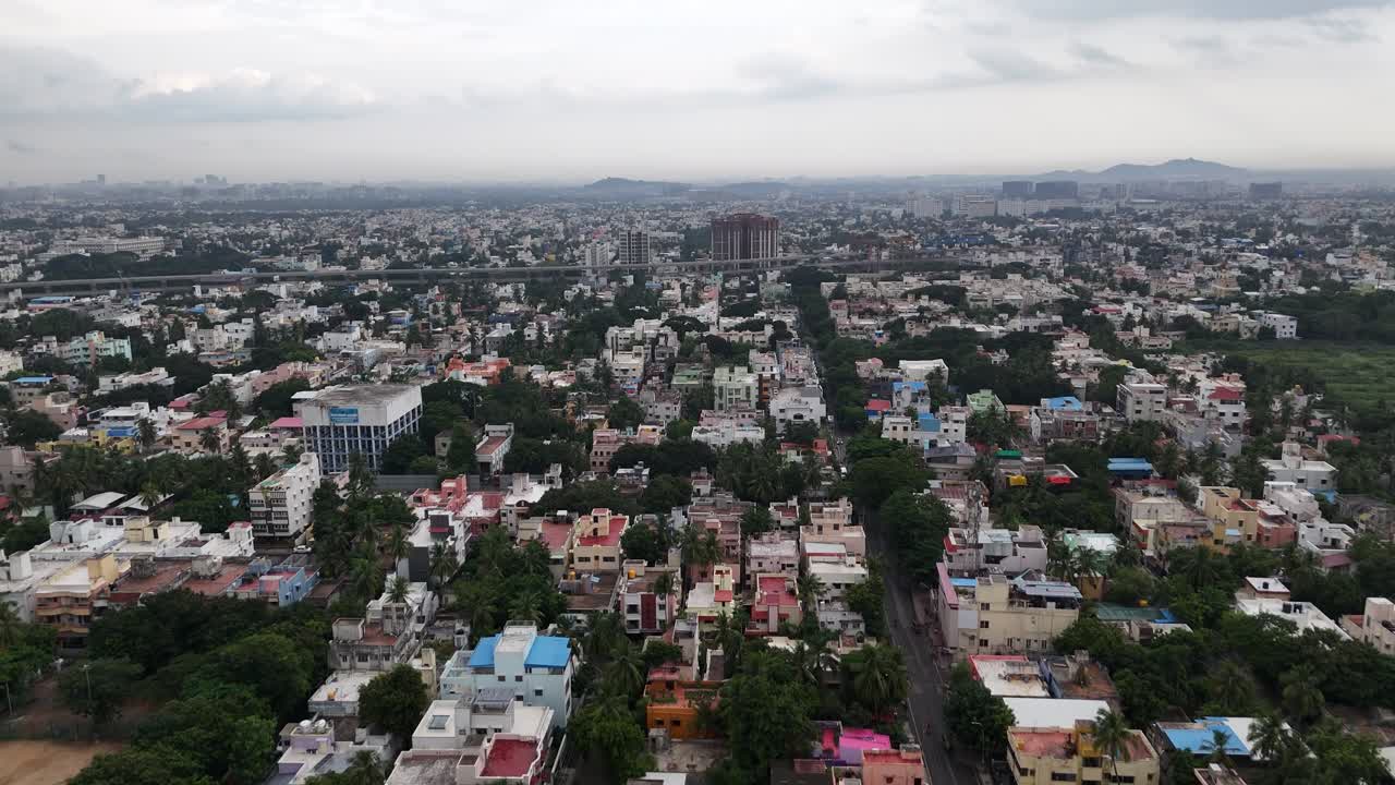 Una ripresa aerea con drone ad alta angolazione rivela le infrastrutture chiave di Chennai durante la stagione delle piogge. Nuvole scure incombenti proiettano una luce cupa sui lavori di costruzione della Fase 2 della Metro. Nuvole scure.