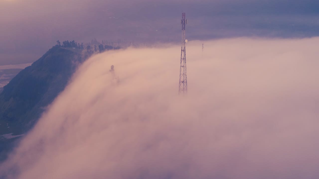 Nebbia che avvolge i vasti paesaggi del Monte Bromo al tramonto, una vista aerea, Indonesia.