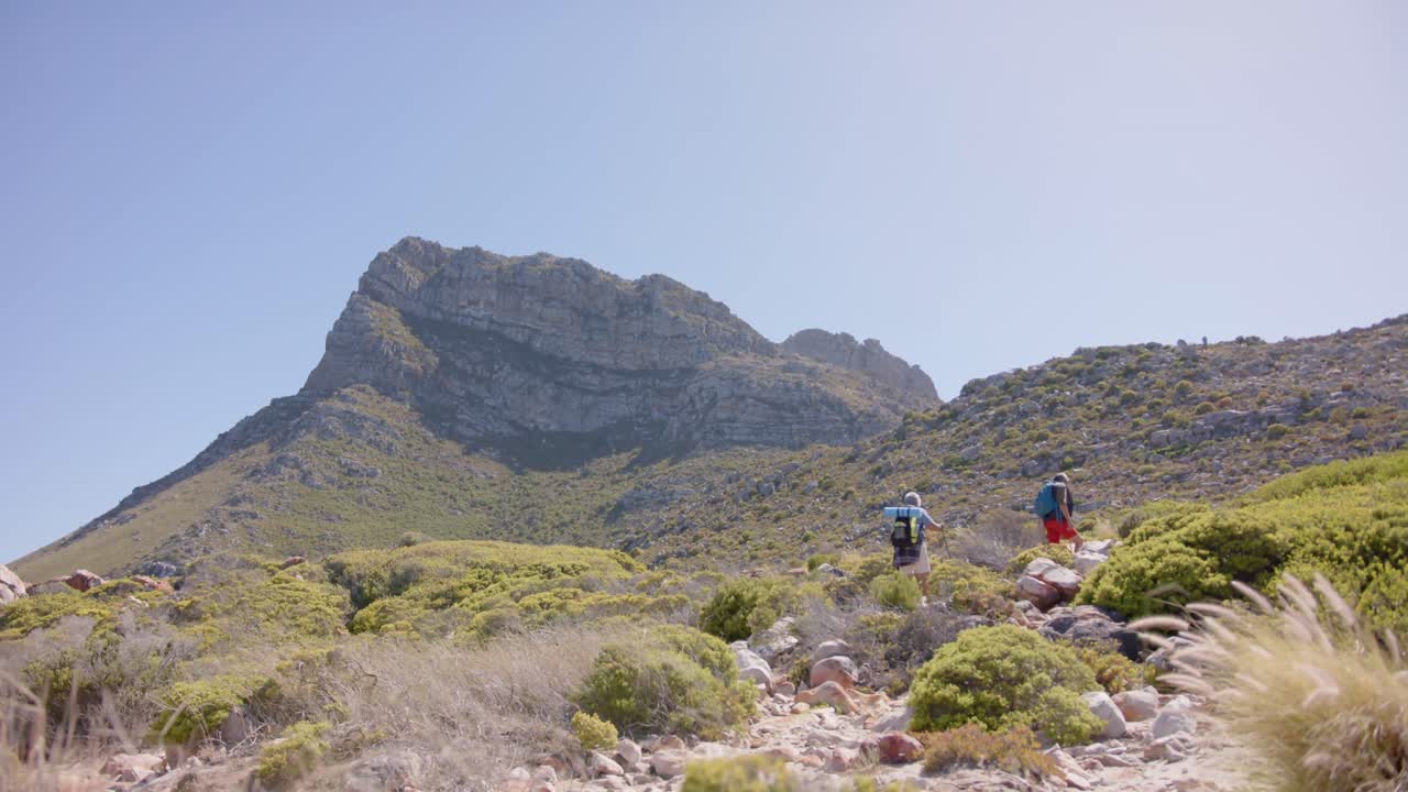 산에서 하이킹을 하는 고령 한 두 인종의 커플, 느린 동작