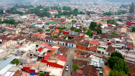 Tilting-up-drone-shot-of-San-Cristobal-de-las-Casas-Mexico,-streets-and-buildings