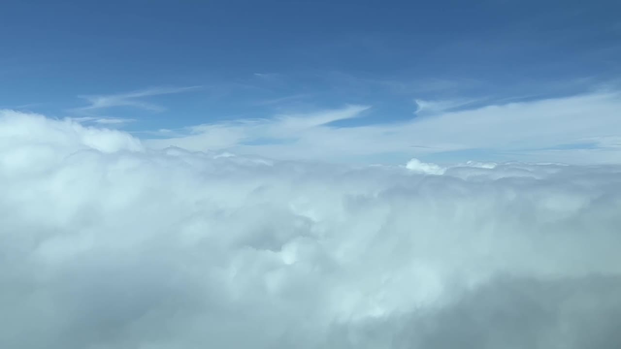 Cockpitudsigt under overflyvning af en overskyet himmel i dagslys