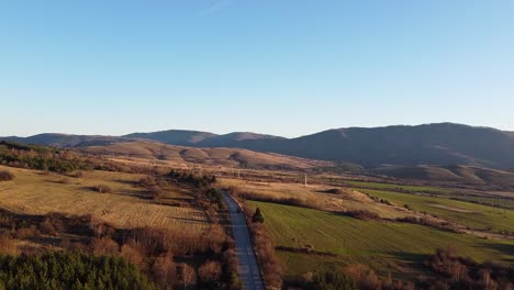 Drone-footage-of-a-vehicle-traveling-on-a-road-in-the-Balkan-mountains,-Bulgaria