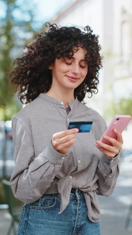mujer caucásica usando un teléfono inteligente con tarjeta de crédito mientras transfiere dinero compras compras en línea