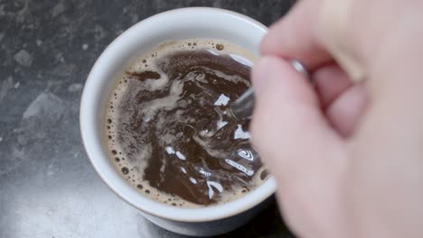 stirring a mug of instant coffee in slow motion