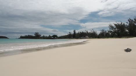 A-beautiful-Tropical-seascape-of-Bermuda's-clear-blue-water,-and-calm-waves-crashing-on-to-the-sand