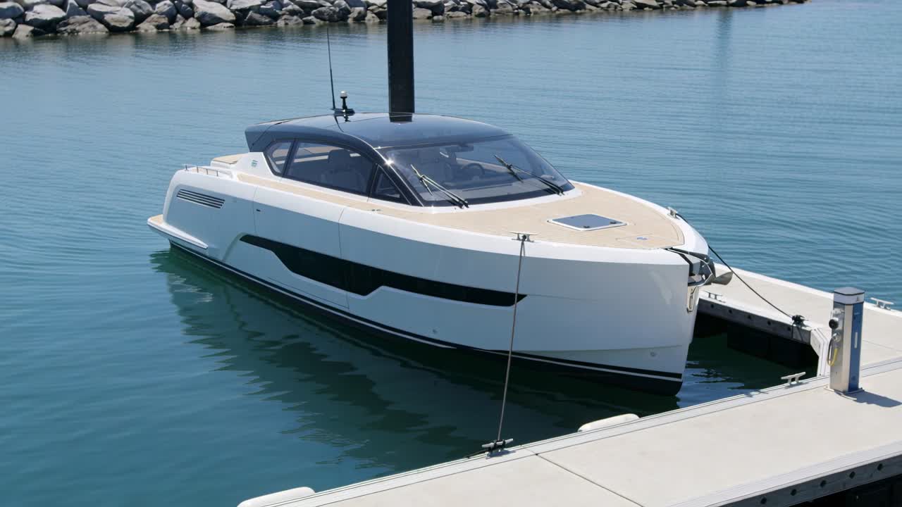 Yacht bianco che dondola legato con una cima d'ormeggio a un molo in un porto turistico riparato, mosso da una leggera brezza