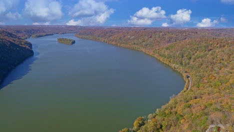 vista aérea de los colores de los árboles de otoño a lo largo de un río importante en un día soleado de otoño