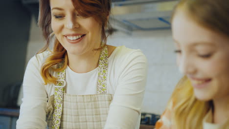 close-up van de schattige grappige moeder en dochter allemaal in het meel lachen, klappen en plezier hebben samen terwijl bakken in de keuken. portret. binnen