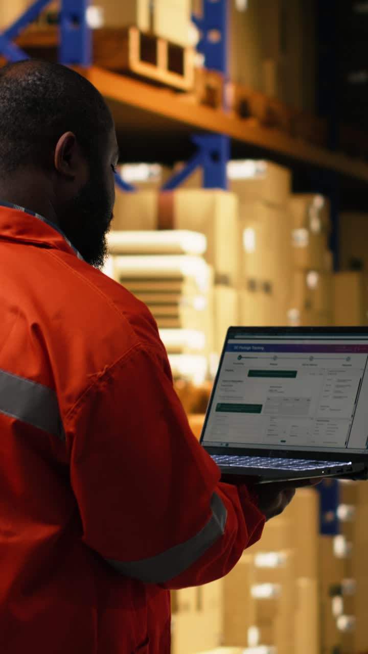 Vertical Video African American Staff Overseeing Cargo On Laptop In Large Business Facility