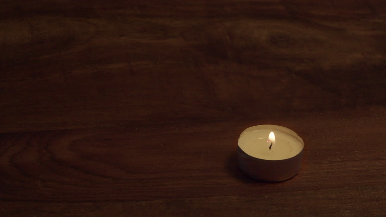 Copy space wooden table top with one tea light candle in lower corner