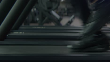 an athlete running full speed on a treadmill , static medium shot