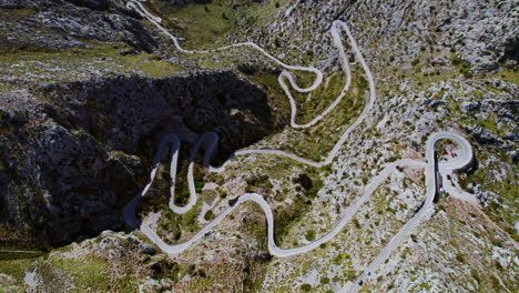 vista aérea desde un avión no tripulado del paso de montaña de coll dels reis con la serpenteante carretera de nus de sa corbata en mallorca, españa