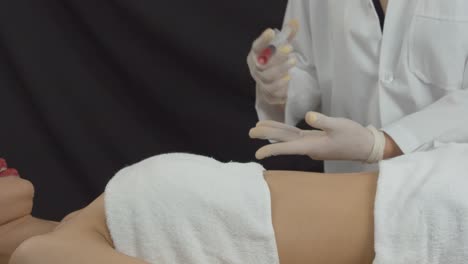 mujer joven que quiere abdominales marcados recibe inyecciones de reducción de grasa o mesoterapia en una clínica de cosmetología