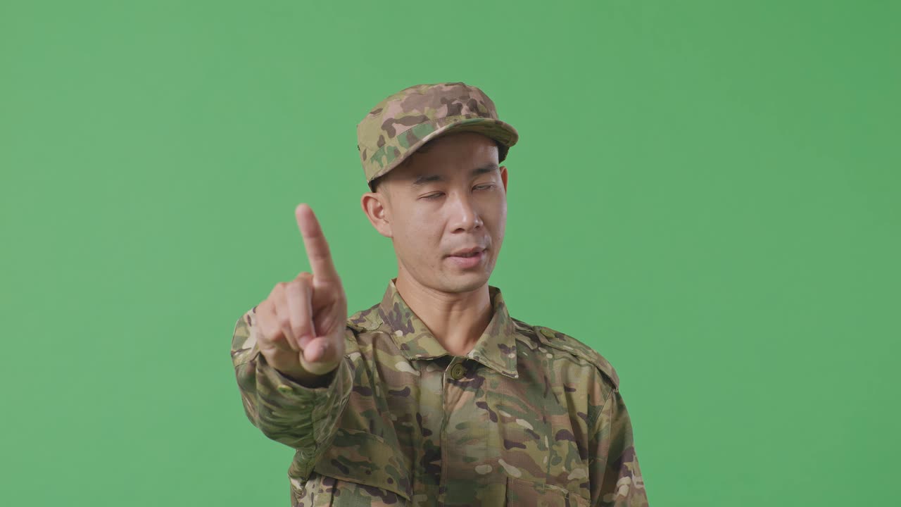 Close Up Of Asian Man Soldier Pointing At You And Disapproving With No Index Finger Sign While Standing In The Green Screen Background Studio