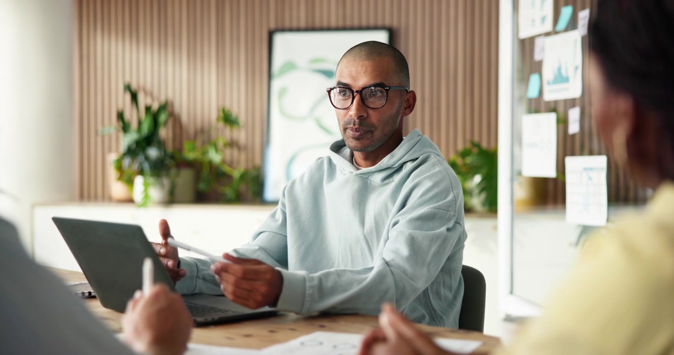 Uomo che guida una riunione di lavoro collaborativa in un ufficio moderno