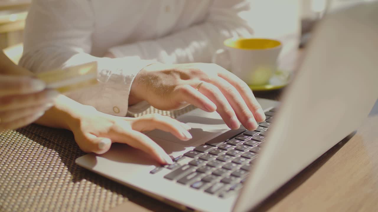 Couple online shopping at a cafe with laptop and credit card