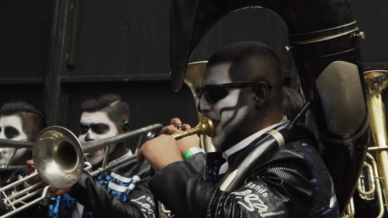 A man in skull makeup plays a musical instrument at the Day of the Dead celebrations in Mexico