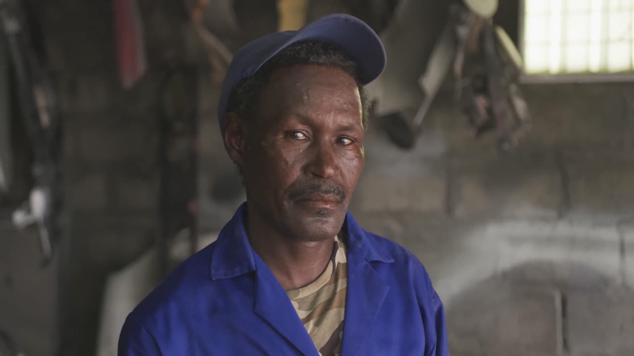Old African handyman looking at camera
