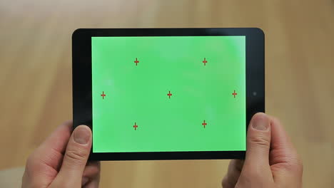 male hands holding tablet with green screen. tablet with chroma key screen