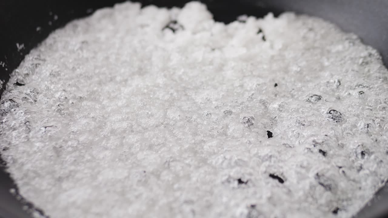 Close up of boiling sugar with bubbles turns into caramel, caramelization, chef cooking dessert in cafe, restaurant pastry food.