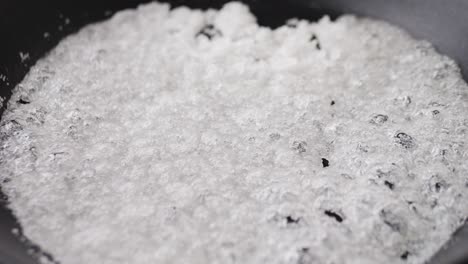 close up of boiling sugar with bubbles turns into caramel, caramelization, chef cooking dessert in cafe, restaurant pastry food.