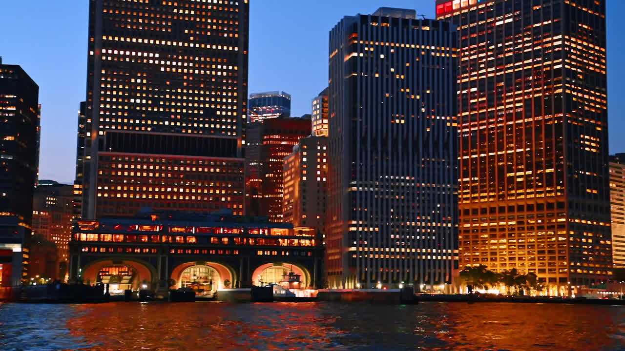 High-rise buildings with illumination switched on. View on the architecture of New York at night from the riverscape