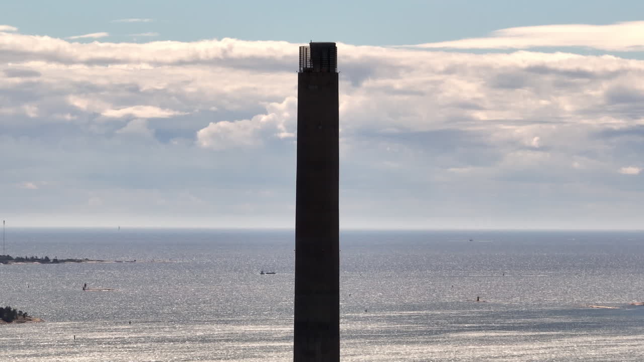 Aerial view orbiting a power plant chimney, summer in Salmisaari, Helsinki