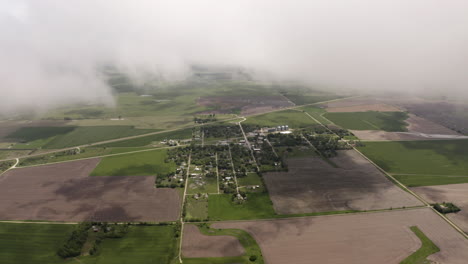 Aerial-drone-moves-through-clouds-above-grassland-and-farmland-in-midwest-of-United-States