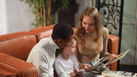 little girl shows relatives on family photos with parents