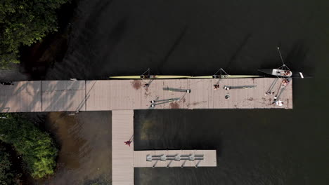 aerial top down view of a rowing dock and training facility in the city lake of rio de janeiro with rowers arriving and coming out of the water